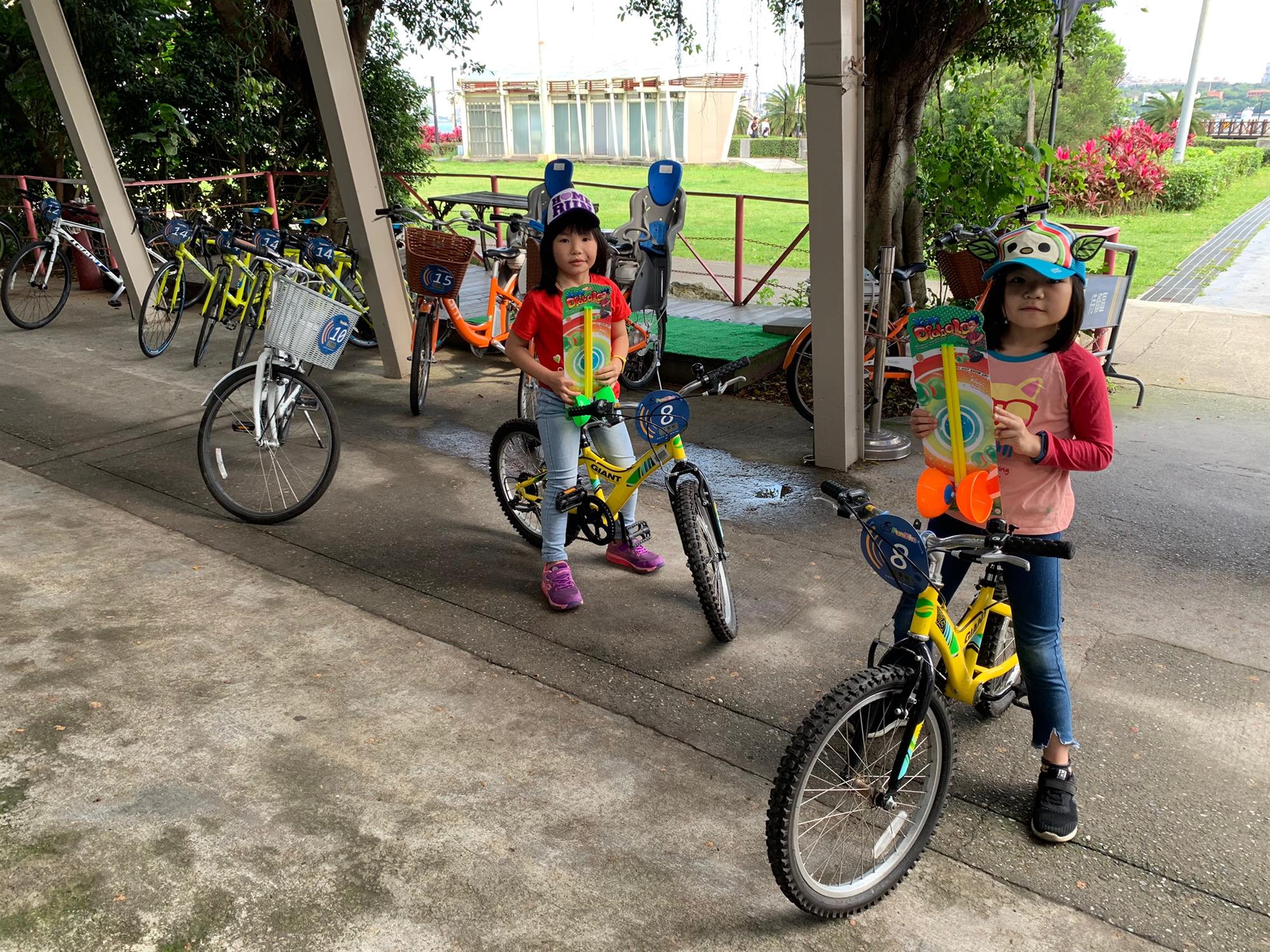 兩位小女孩騎著黃色自行車合照